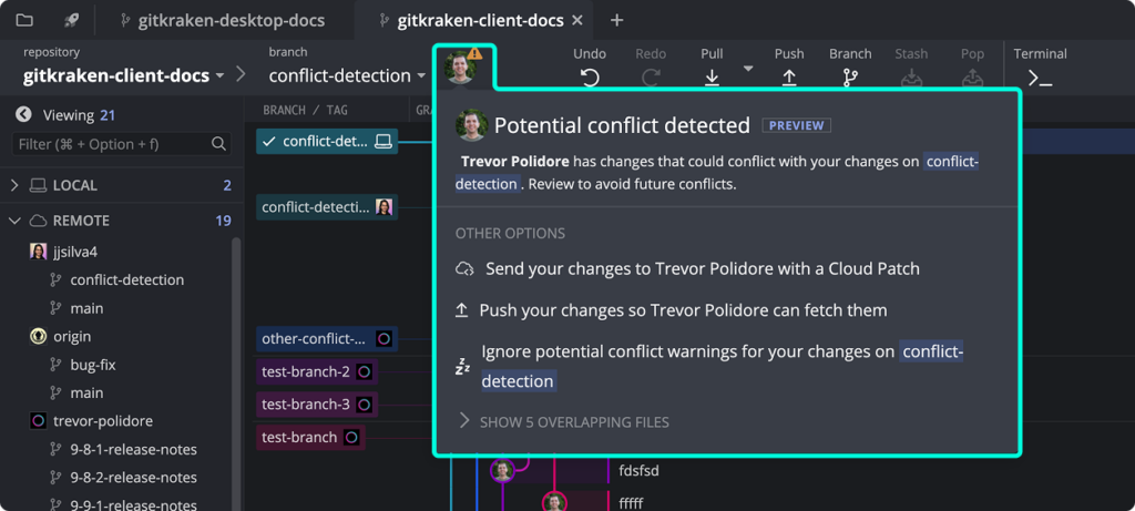 In GitKraken Desktop, clicking a conflict warning expands to show details about a potential merge conflict. The menu lists the conflicted branches and provides options to send changes as a cloud patch, push changes, or ignore.